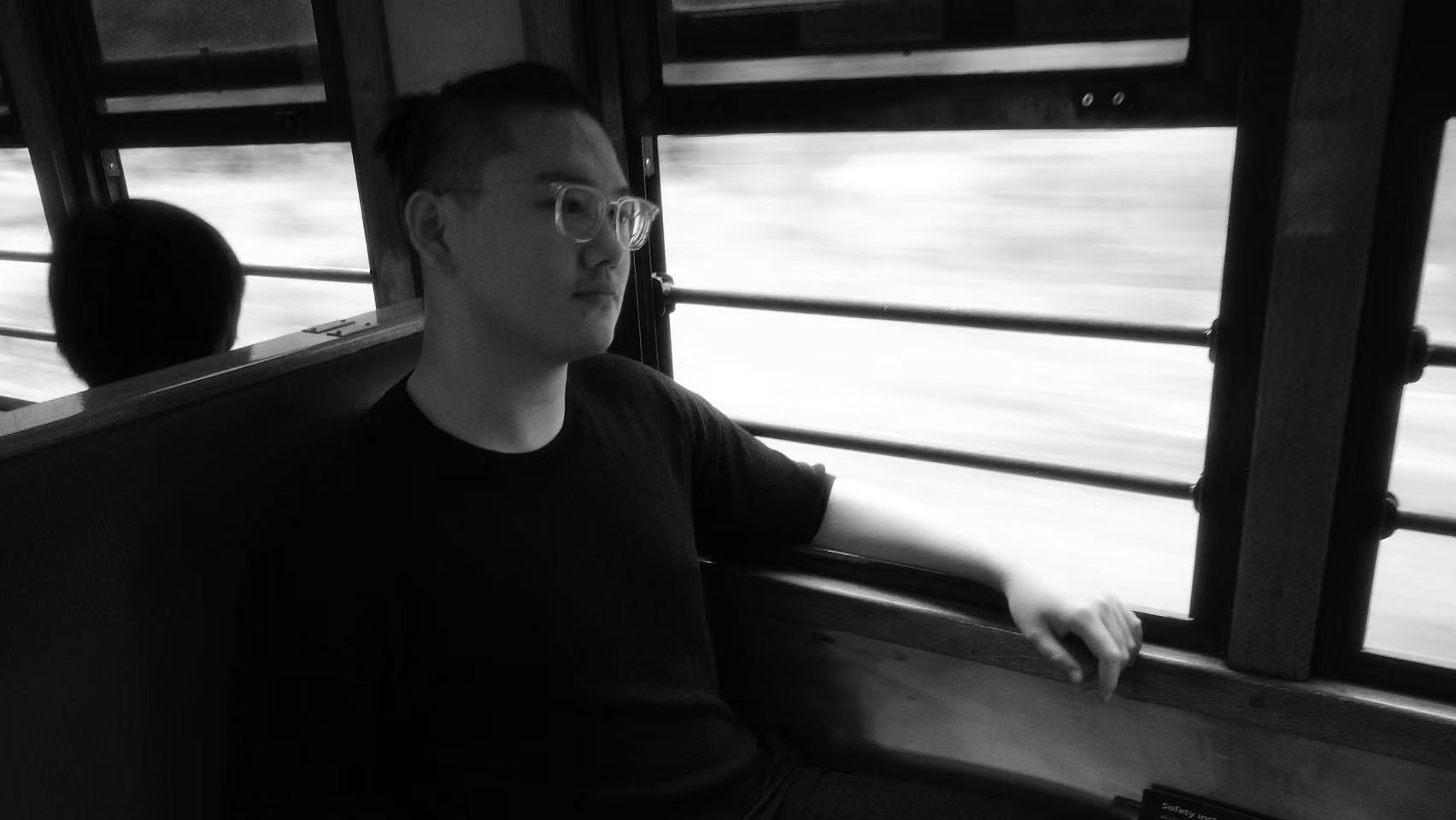 Jesse Liu sitting beside a moving train window