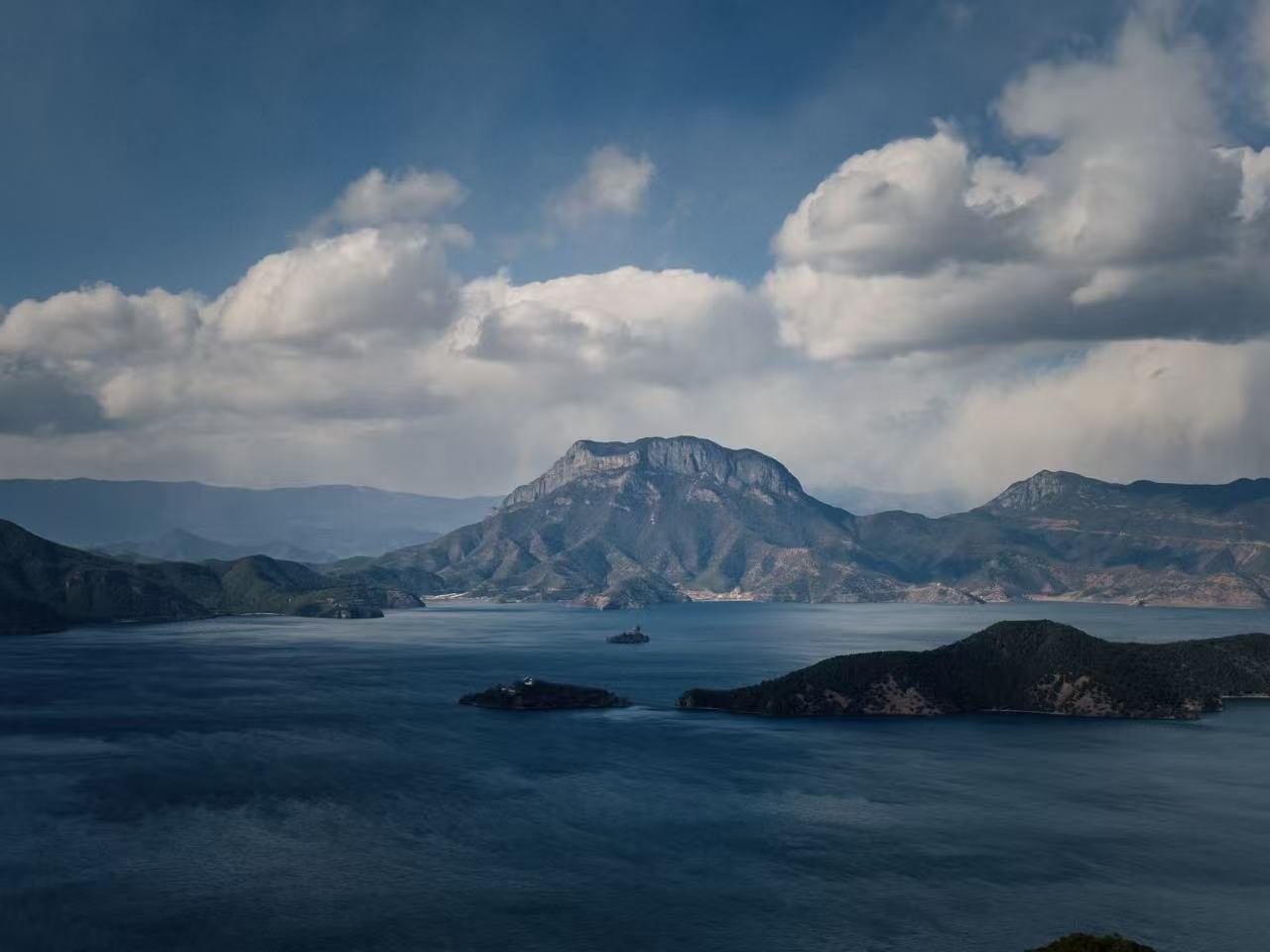 Mountain lake beneath moving clouds