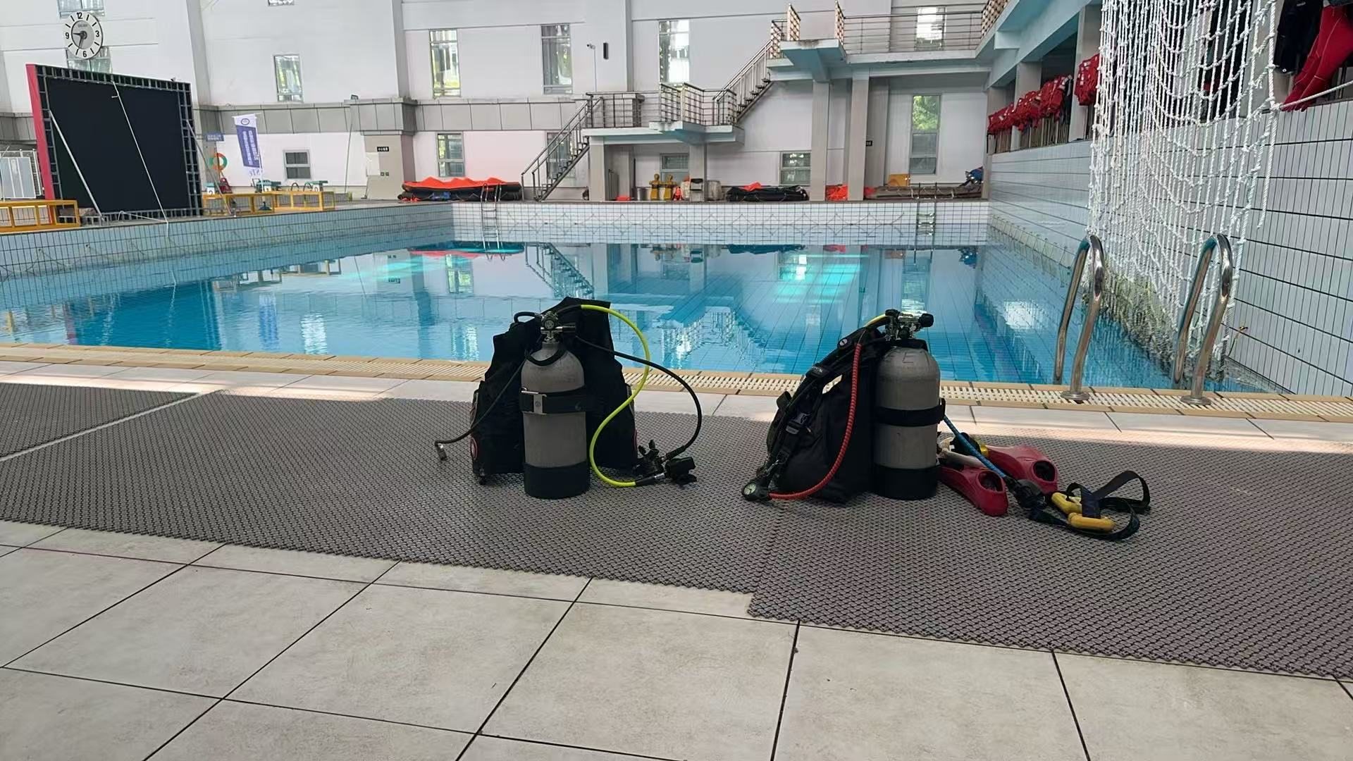 Scuba diving equipment beside a swimming pool