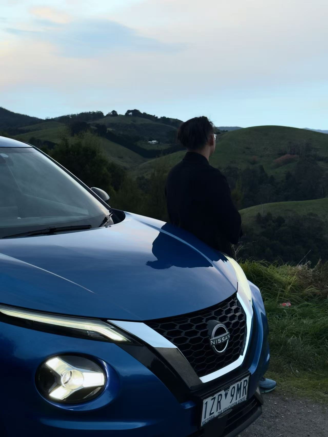 Jesse Liu beside a car in rolling hills